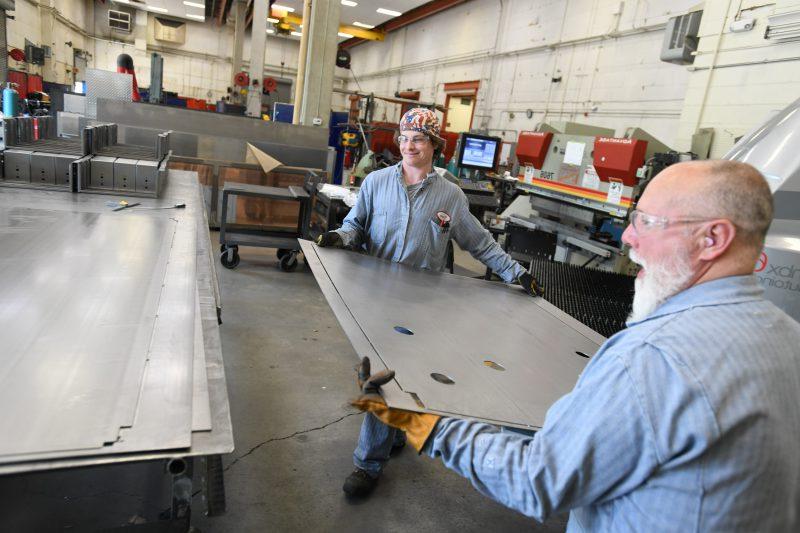 Image of two mechanics working in a fabrication shop.